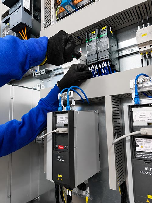 Tecnico al lavoro su quadro elettrico industriale